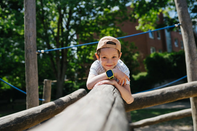 Happy kid having fun at the playground witha GPS smartwatch for kids. Safety and peace of mind by the hand for the family.