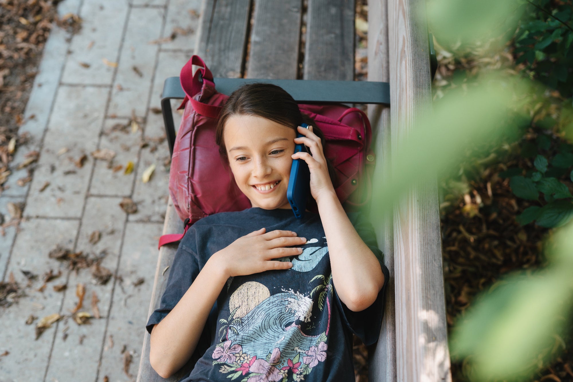 Gril talking to her friends after school on her kids phone.