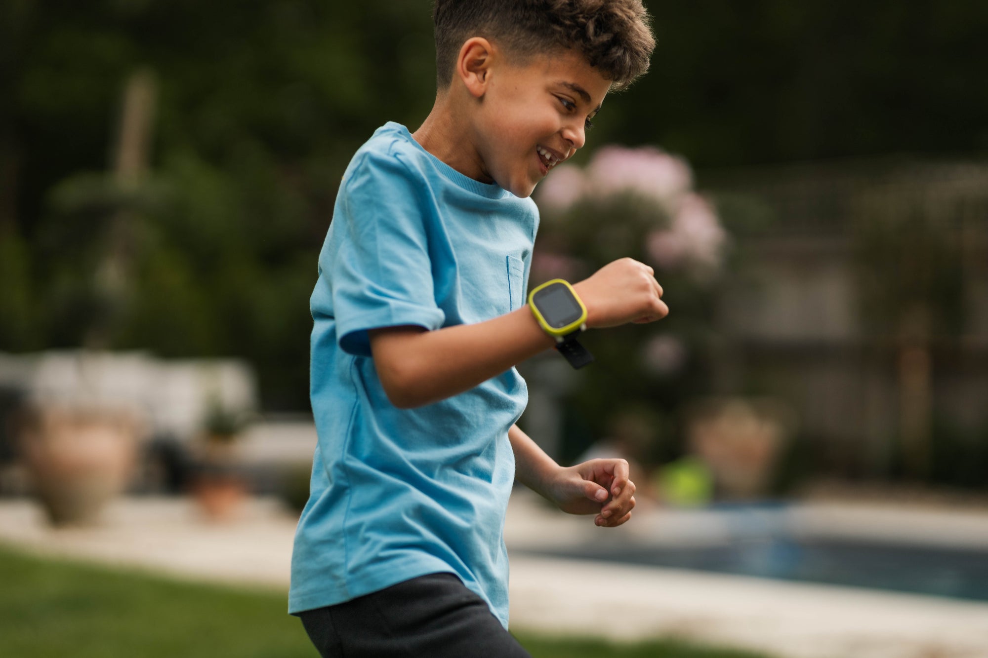 Boy playing around during the day with a Kids Smartwatch with GPS attached to the hand for easy contact.